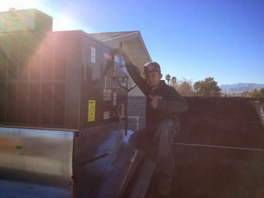 HVAC technician performing Boiler Repair on a rooftop unit in Joplin